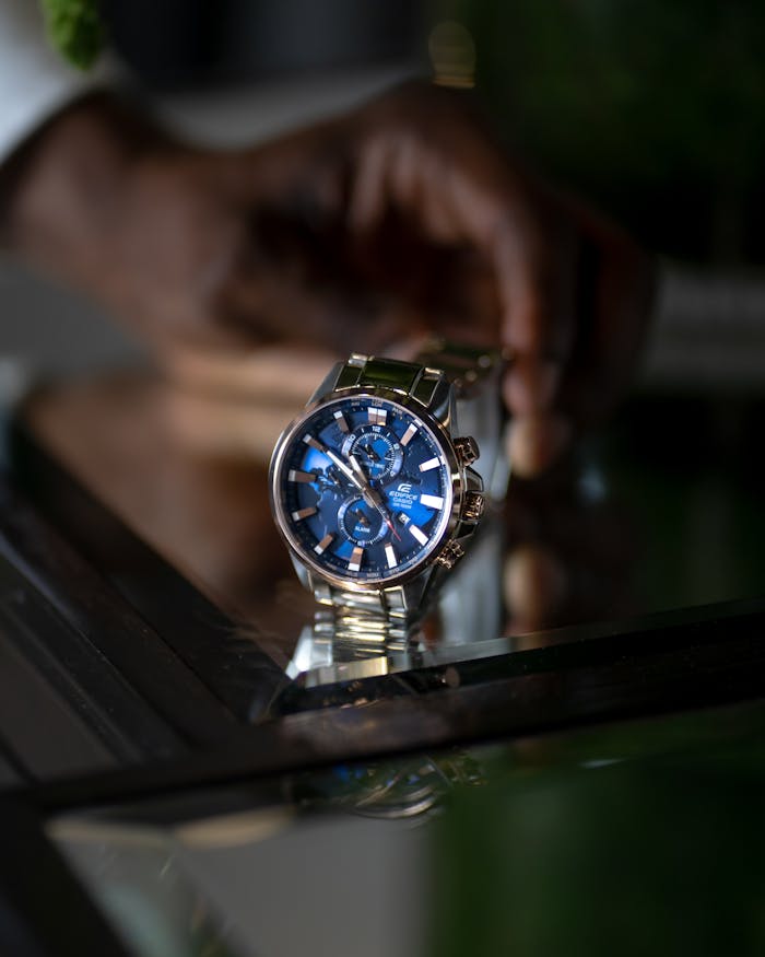 Close-up of a stylish silver wristwatch with a blue dial and chronograph features.
